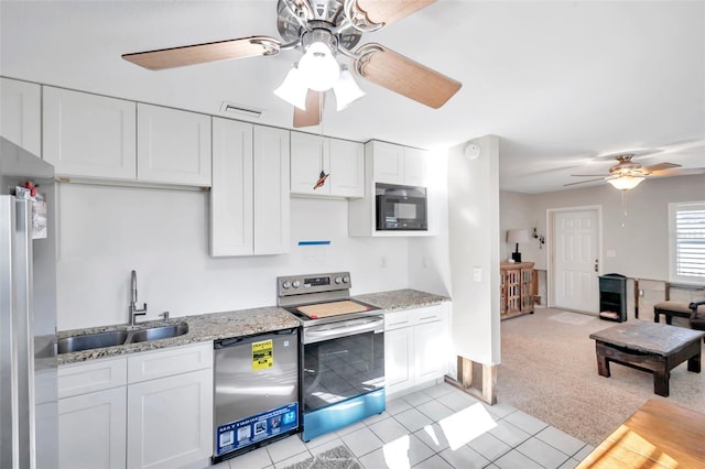 kitchen with light colored carpet, white cabinetry, sink, and appliances with stainless steel finishes