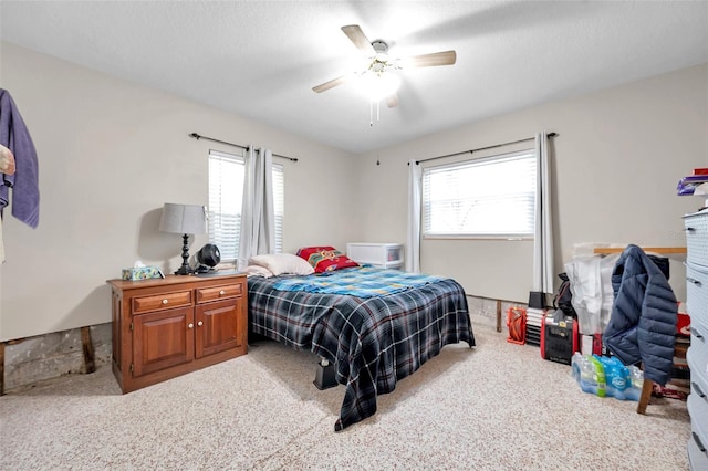 bedroom with light carpet, a textured ceiling, multiple windows, and ceiling fan