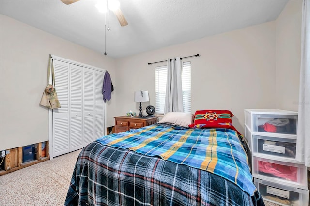 carpeted bedroom with ceiling fan, a closet, and a textured ceiling