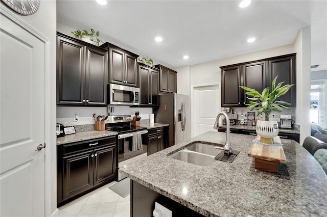 kitchen with light stone countertops, light tile patterned floors, stainless steel appliances, and sink