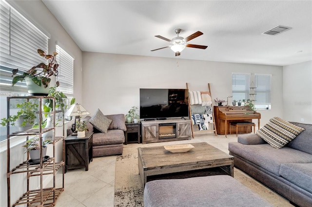 tiled living room featuring ceiling fan and plenty of natural light