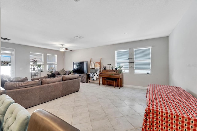 tiled living room featuring ceiling fan and plenty of natural light