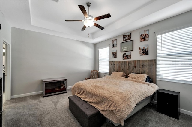 bedroom with ceiling fan, a raised ceiling, and light colored carpet