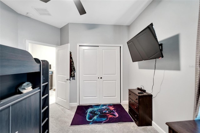 bedroom featuring ceiling fan, light colored carpet, and a closet