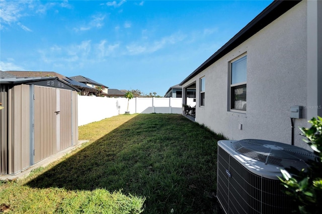 view of yard featuring cooling unit and a storage shed