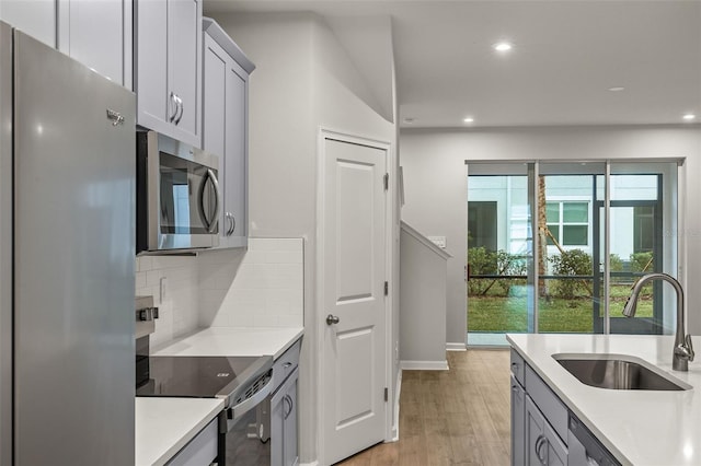 kitchen with appliances with stainless steel finishes, sink, a wealth of natural light, and backsplash