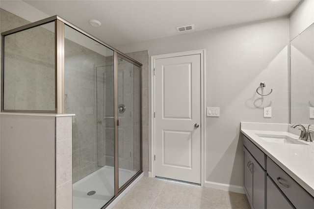 bathroom with an enclosed shower, vanity, and tile patterned floors