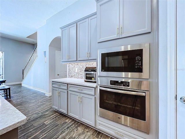 kitchen featuring decorative backsplash, dark wood-type flooring, and appliances with stainless steel finishes