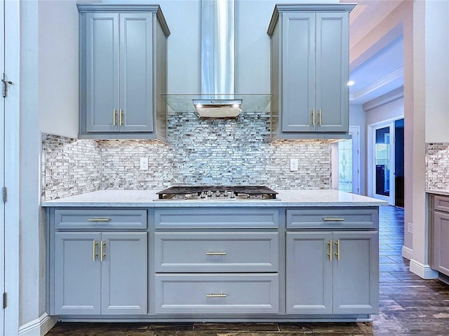 kitchen with backsplash, gray cabinets, wall chimney exhaust hood, and stainless steel gas cooktop