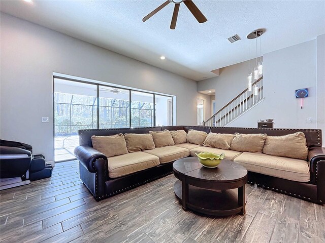 living room featuring ceiling fan, wood-type flooring, and a textured ceiling