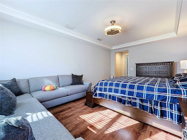 bedroom with a textured ceiling, dark hardwood / wood-style flooring, and crown molding