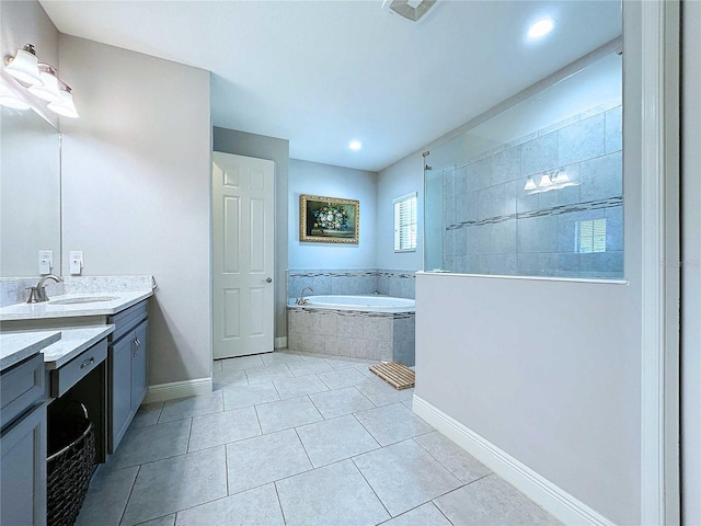 bathroom featuring tiled bath, tile patterned flooring, and vanity