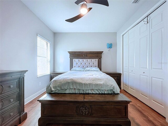 bedroom featuring ceiling fan, light hardwood / wood-style floors, and a closet