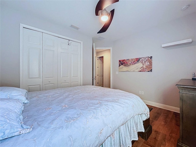 bedroom with ceiling fan, dark wood-type flooring, and a closet