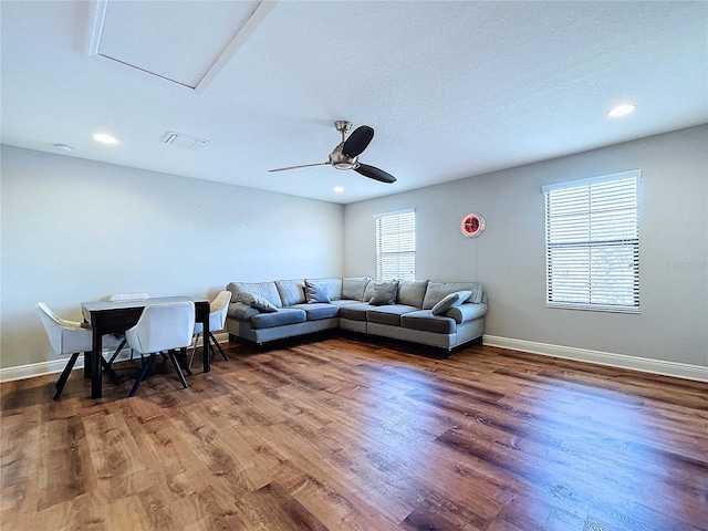 living room featuring dark hardwood / wood-style flooring and ceiling fan