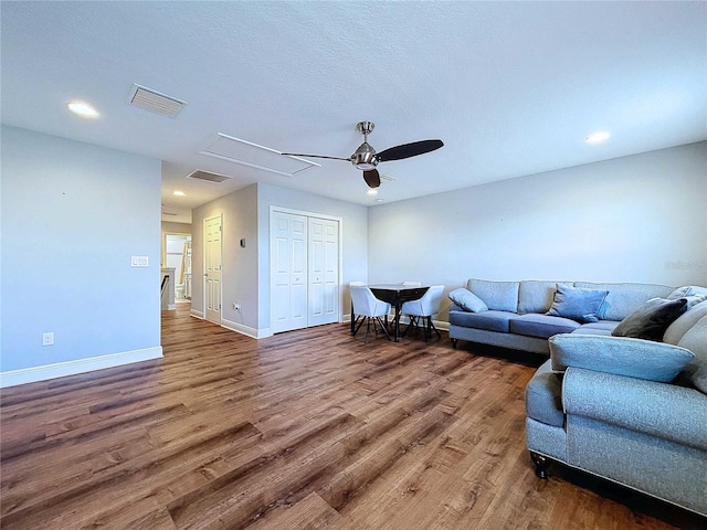 living room with hardwood / wood-style floors, ceiling fan, and a textured ceiling