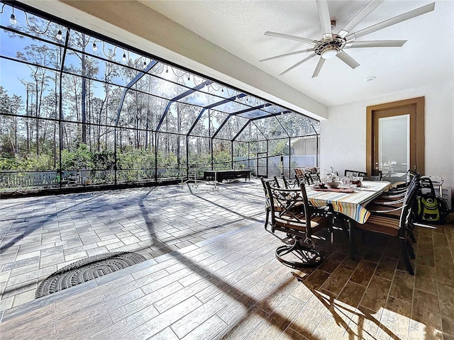 view of patio with glass enclosure and ceiling fan