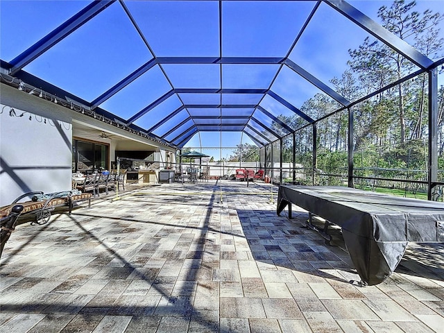 view of patio with glass enclosure and ceiling fan