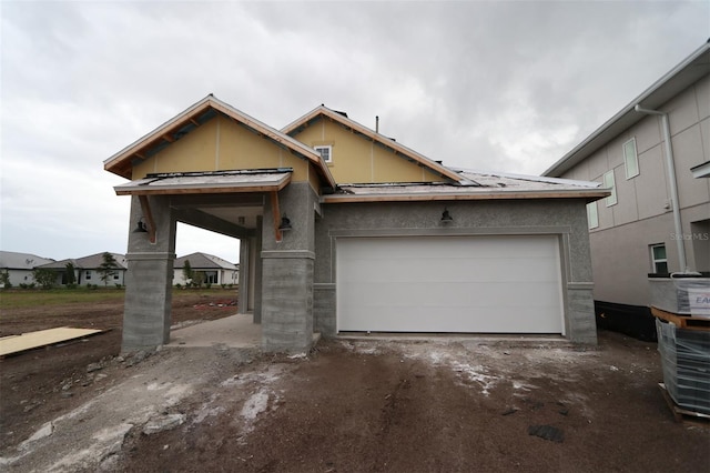 view of front of house with a garage, driveway, and stucco siding