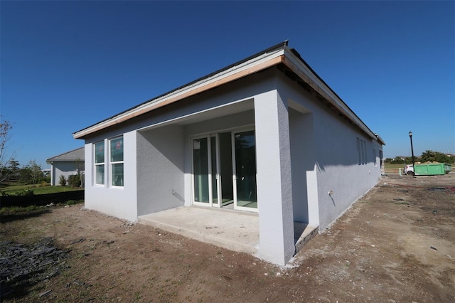 rear view of property with stucco siding