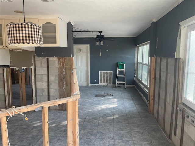 unfurnished living room featuring ceiling fan and crown molding