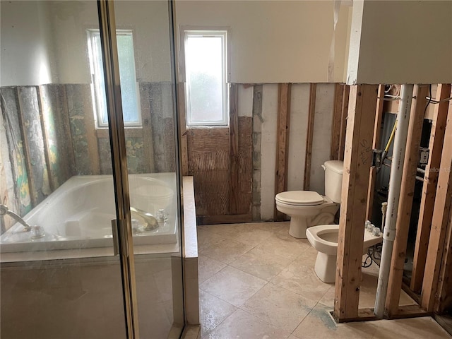 bathroom with tile patterned floors, a tub, a bidet, and toilet