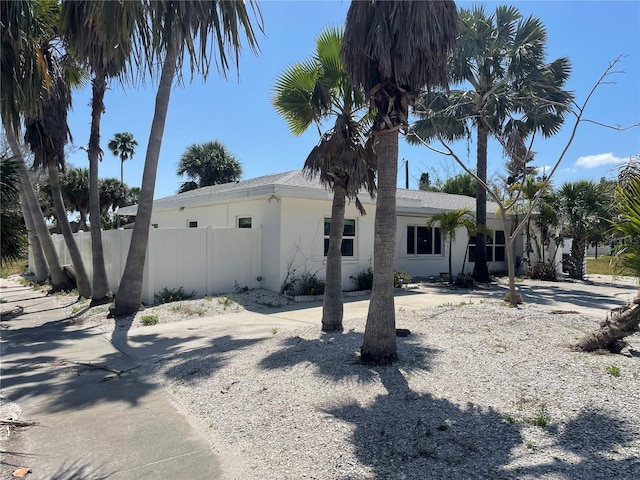 909 Mandalay Ave, Clearwater Beach, FL 33767 - view of side of home with fence and stucco siding