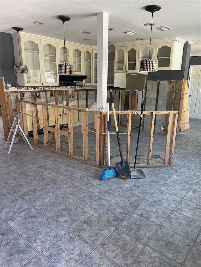 909 Mandalay Ave, Clearwater Beach, FL 33767 - interior space with glass insert cabinets, a textured ceiling, and pendant lighting