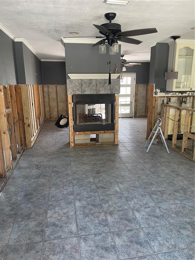909 Mandalay Ave, Clearwater Beach, FL 33767 - unfurnished living room with a textured ceiling, ceiling fan, a tiled fireplace, and ornamental molding
