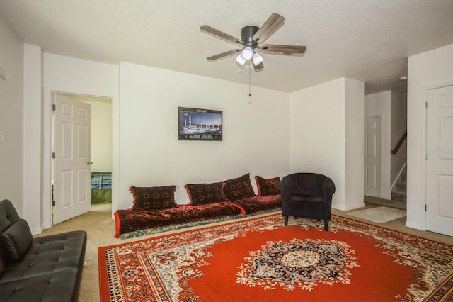 living room featuring carpet flooring, a textured ceiling, and ceiling fan