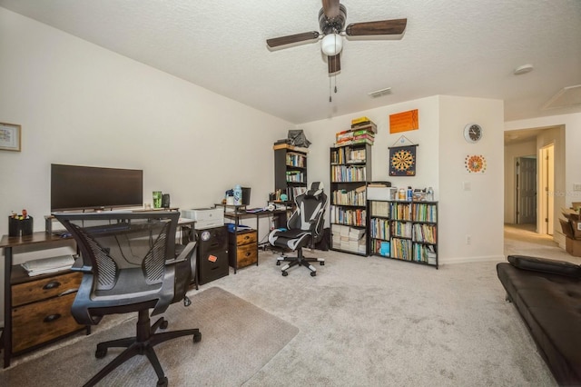 carpeted office featuring ceiling fan and a textured ceiling