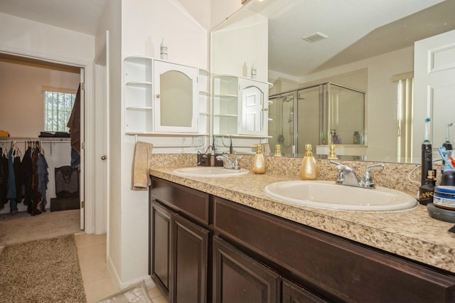 bathroom featuring tile patterned flooring, vanity, vaulted ceiling, and walk in shower