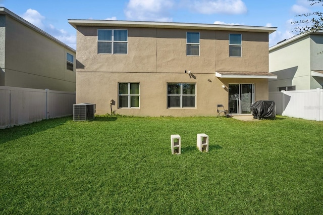 back of house featuring a lawn and central air condition unit