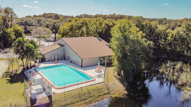 view of pool featuring a lawn, a patio area, and a water view