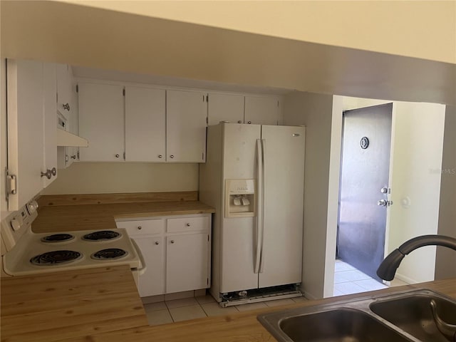 kitchen with light tile patterned flooring, white appliances, white cabinetry, and sink