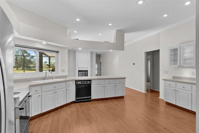 kitchen with white cabinets, electric range, sink, and light hardwood / wood-style flooring