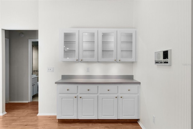 kitchen featuring white cabinets, stainless steel counters, and light hardwood / wood-style flooring