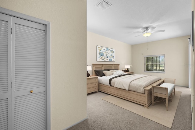 carpeted bedroom featuring ceiling fan and a closet