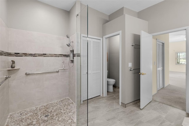 bathroom with toilet and a tile shower