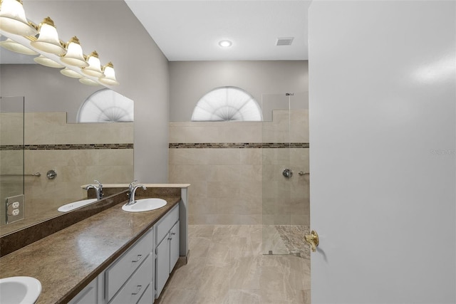 bathroom with vanity and a tile shower