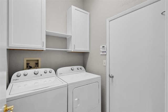 laundry area featuring washer and clothes dryer and cabinets