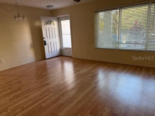 foyer entrance featuring hardwood / wood-style flooring and a notable chandelier