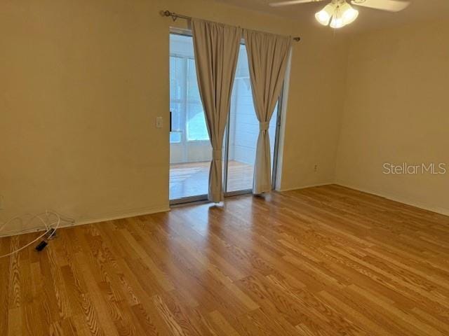 spare room with ceiling fan and light wood-type flooring