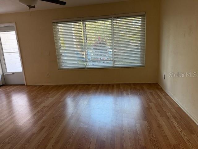 spare room featuring ceiling fan, plenty of natural light, and hardwood / wood-style floors