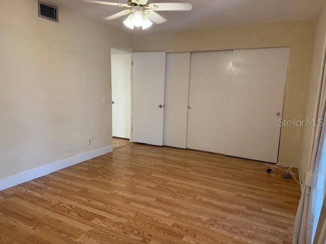 unfurnished bedroom featuring light wood-type flooring and ceiling fan