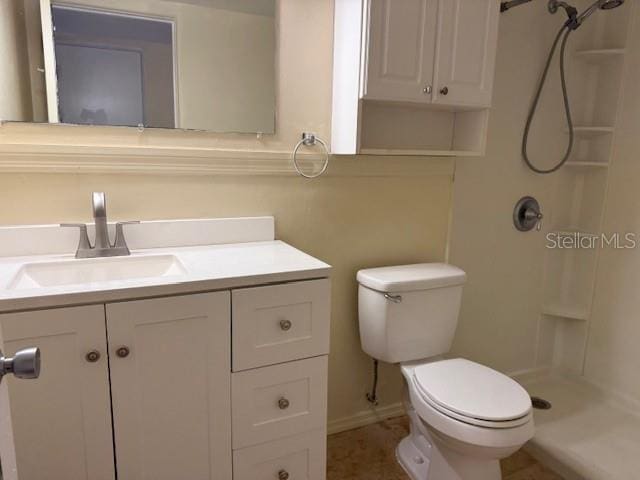 bathroom featuring vanity, toilet, and a shower