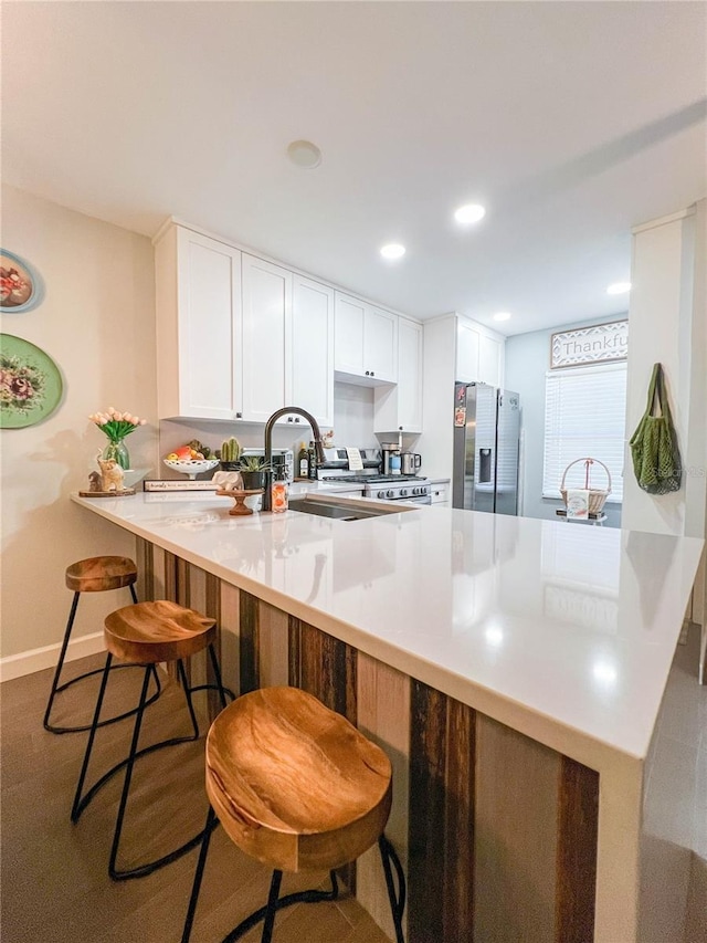 kitchen with a breakfast bar, white cabinetry, stainless steel fridge with ice dispenser, and kitchen peninsula