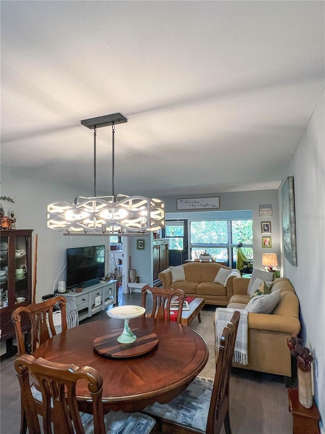 dining space featuring dark colored carpet and a notable chandelier