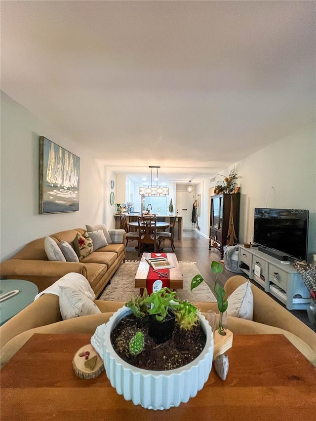 living room with hardwood / wood-style floors and a notable chandelier