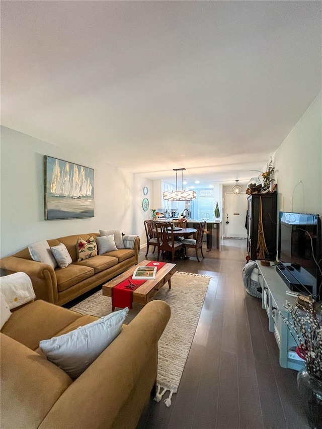 living room with a chandelier and dark hardwood / wood-style floors